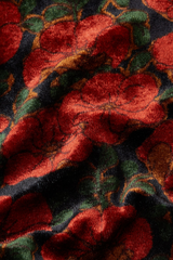 Detailaufnahme eines retro-inrpirierten Samtstoffes mit rotem Blumenmuster