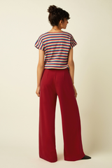 Gestreiftes buntes T-Shirt kombiniert mit roten Stoffhosen von King Louie für den Sommer im Youmee.market Bern