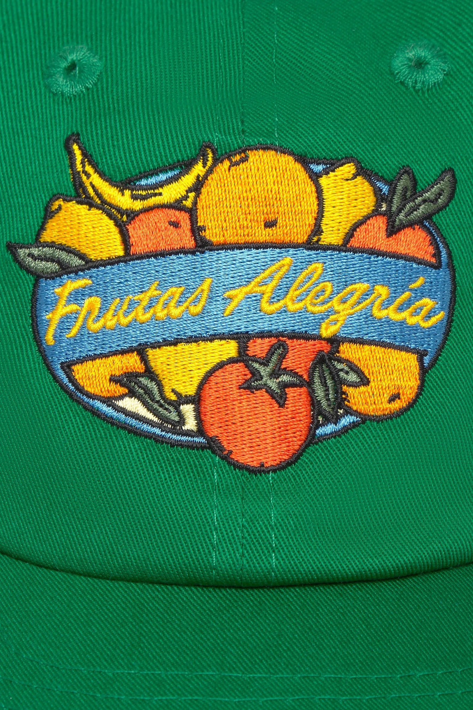 Detail der bunten Frutas Alegria Stickerei auf der grünen Thinking MU Cap