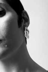 getragener ohrschmuck von mimimono aus recyceltem acryl in gold und geometrischer wellenform im youmee.market bern