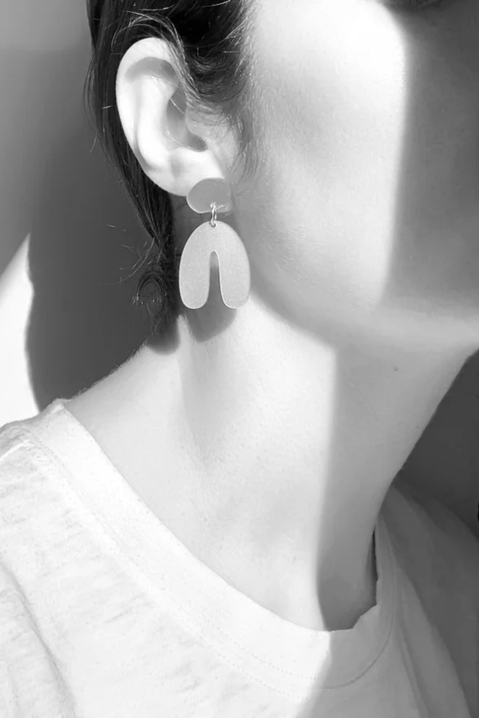 getragener ohrschmuck von mimimono aus recyceltem acryl mit geometrischer u form in rosa und gold im youmee.market bern