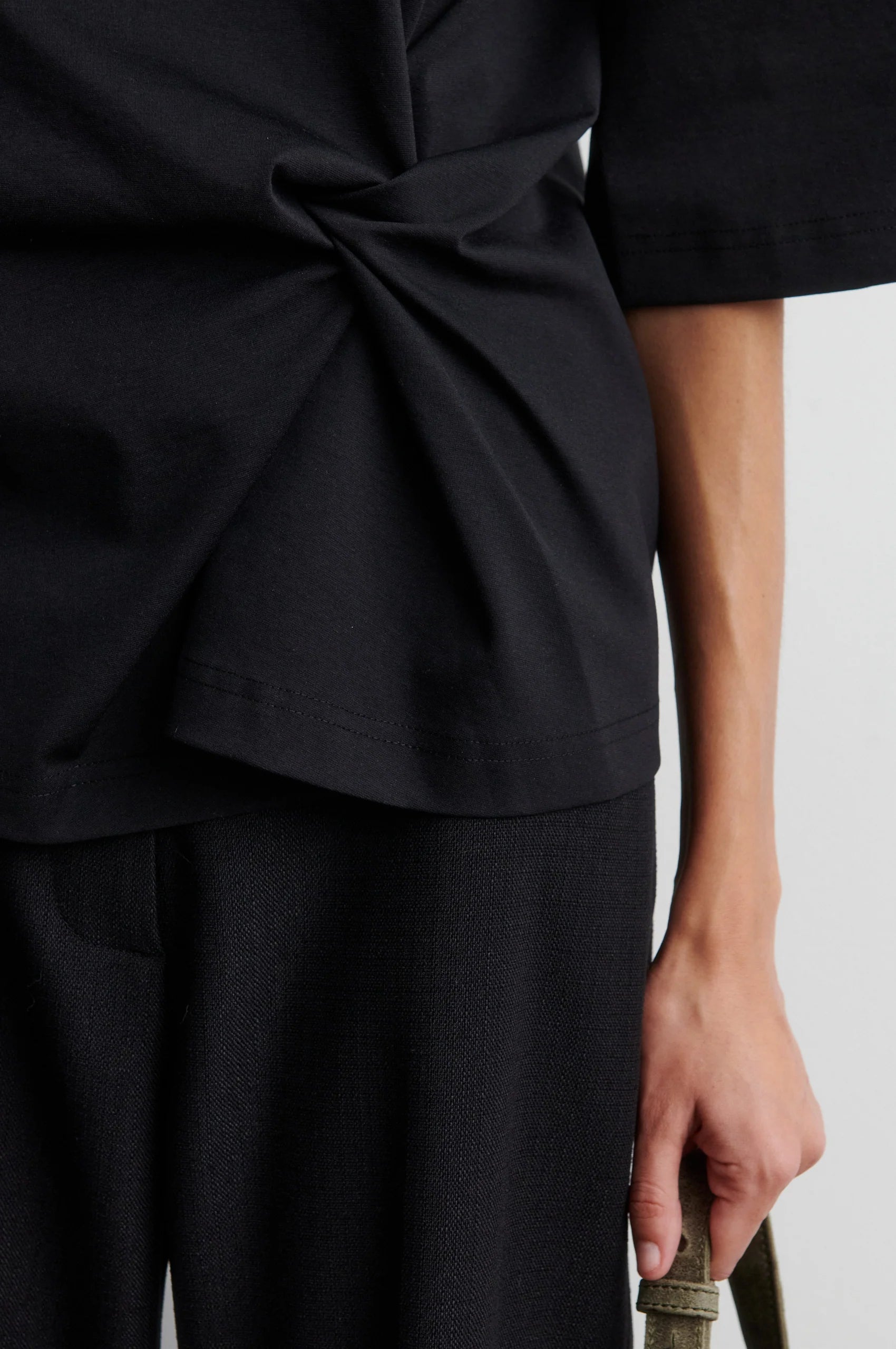 Detail der asymmetrischen seitlichen Drapierung am schwarzen Second Female Arkai Top