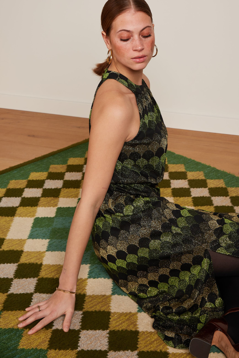 Jacquard Kleid mit glitzer-grünem Peacock Muster auf einem grün-karierten Teppich