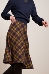 Midi-Rock mit Tartan Muster, kombiniert mit schwarzen Stiefeln und blauem Pullover