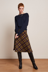 Midi-Rock mit Tartan Muster, kombiniert mit schwarzen Stiefeln und blauem Pullover