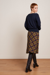 Midi-Rock mit Tartan Muster, kombiniert mit schwarzen Stiefeln und blauem Pullover