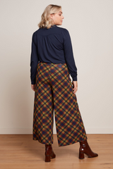 weite Culotte-Hose mit kartiertem Tartan Muster, kominiert mit bordeaux-roten Stiefeletten