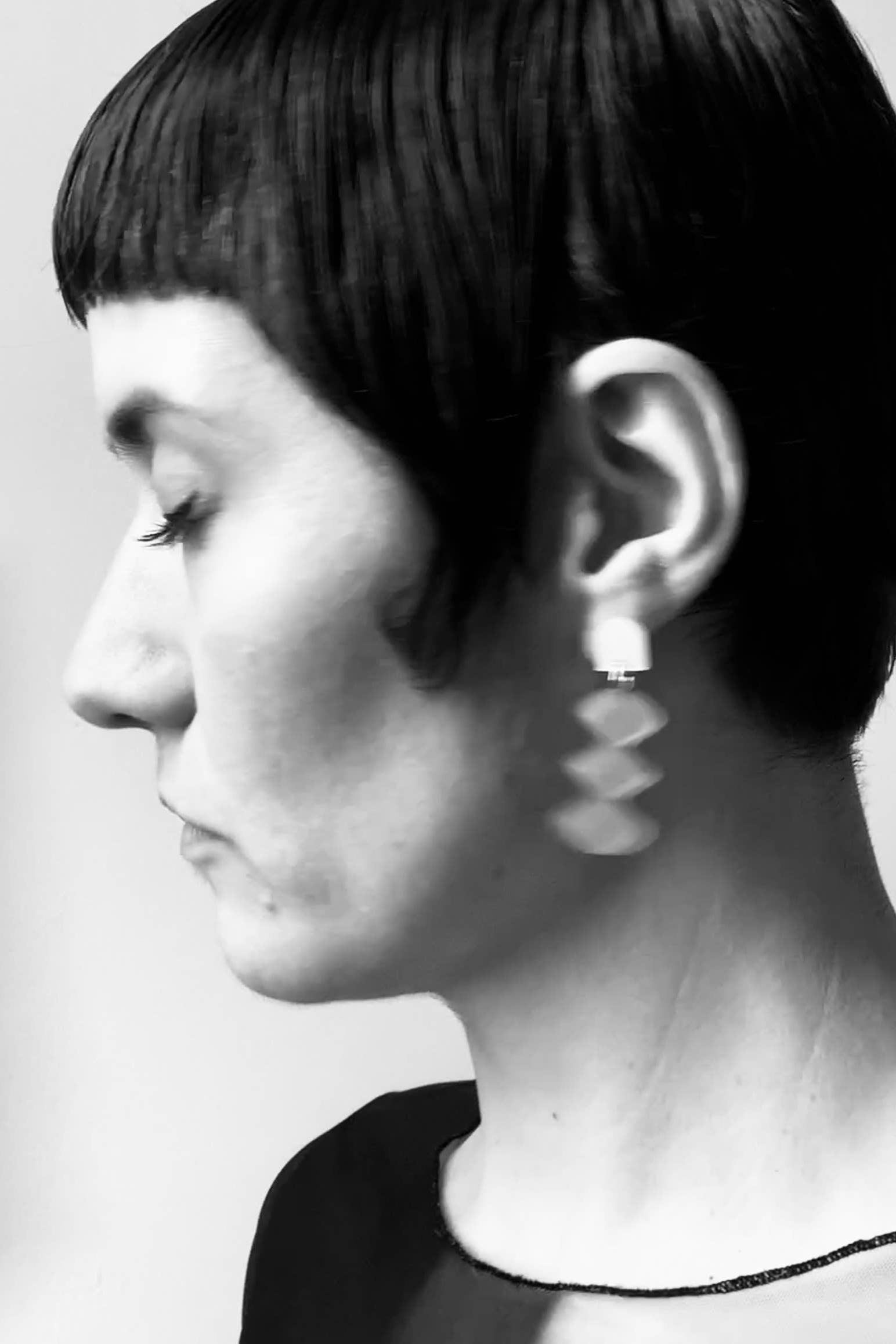 getragener ohrschmuck von mimimono aus recyceltem acryl in geometrischer form und oranger farbe im youmee.market bern