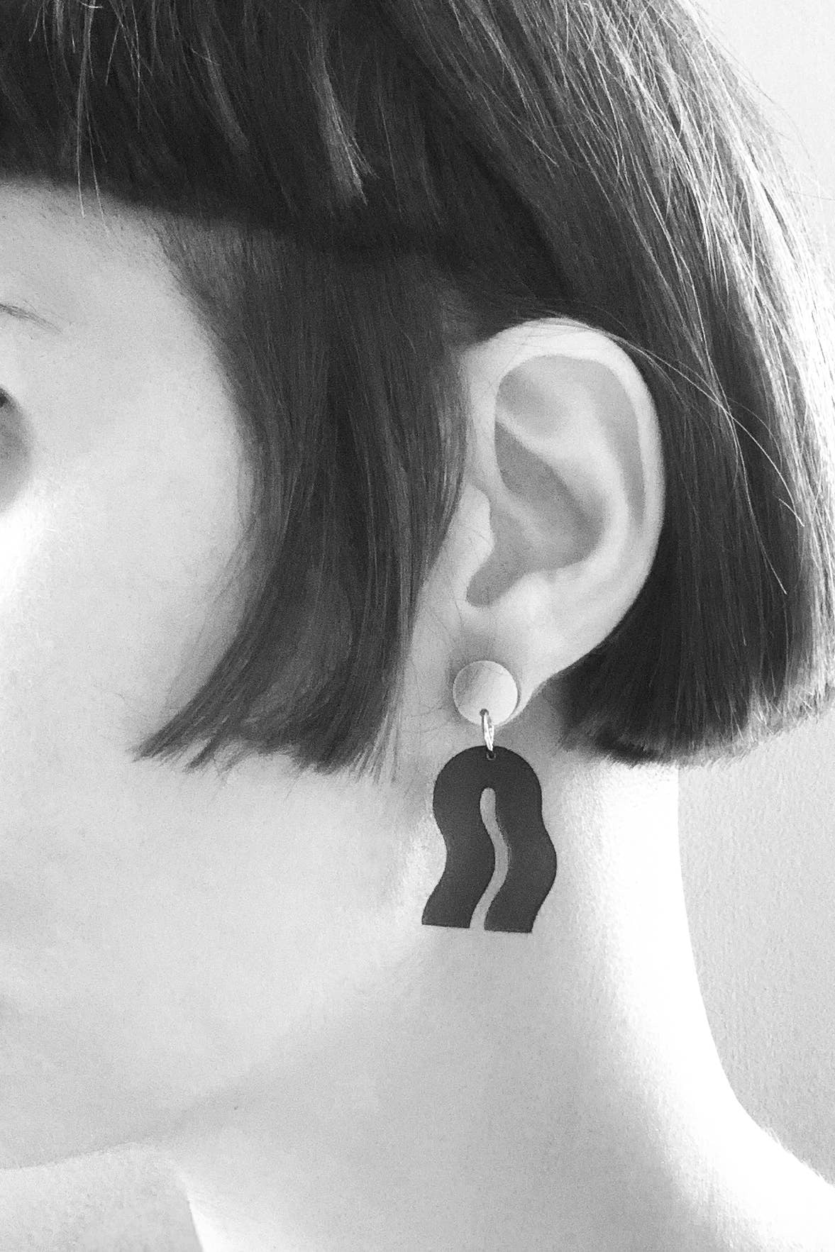 getragener ohrschmuck von mimimono aus recyceltem acryl in geometrischer wellenform in blau und gold im youmee.market bern